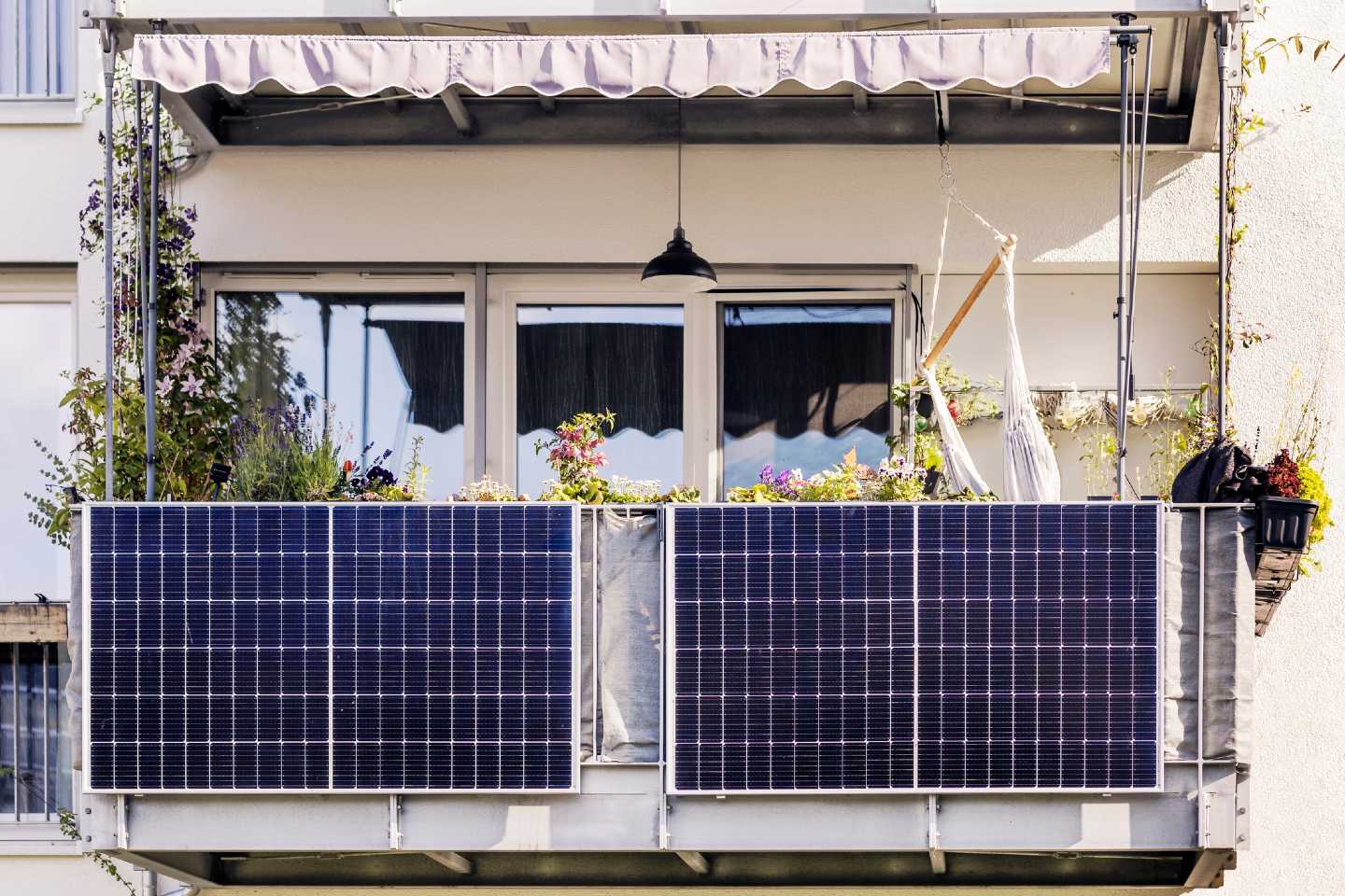 Solarmodule an einem bunt bepflanzten Balkon.