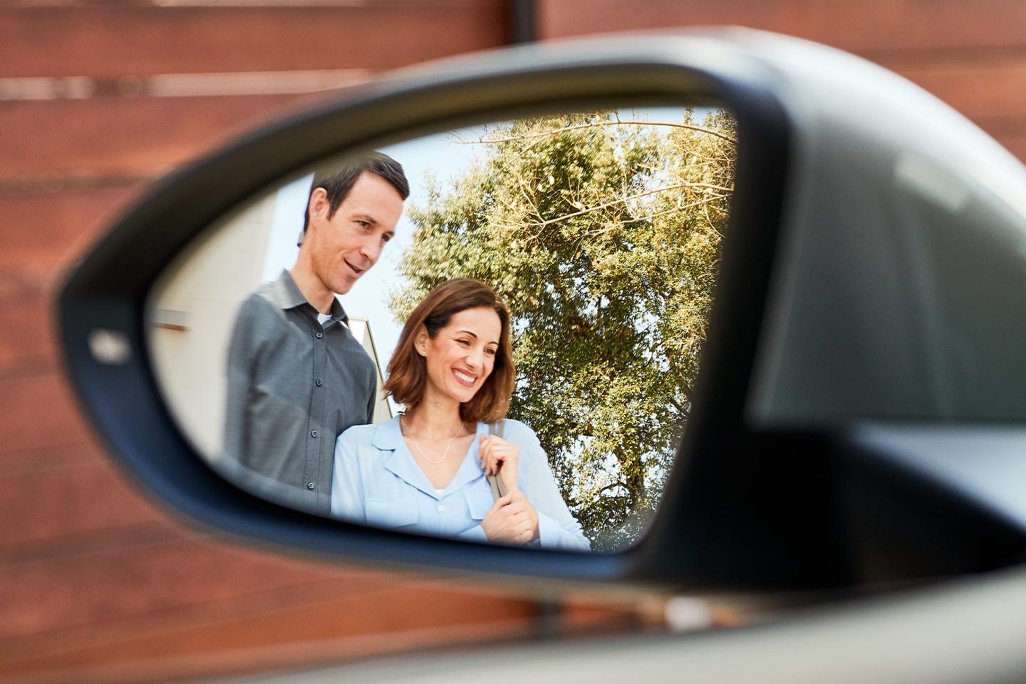 Junges Paar im Rückspiegel eines Autos.